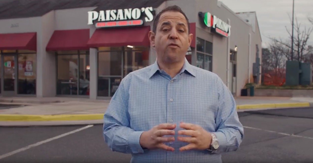 Paisano's founder in front of a Paisano's storefront