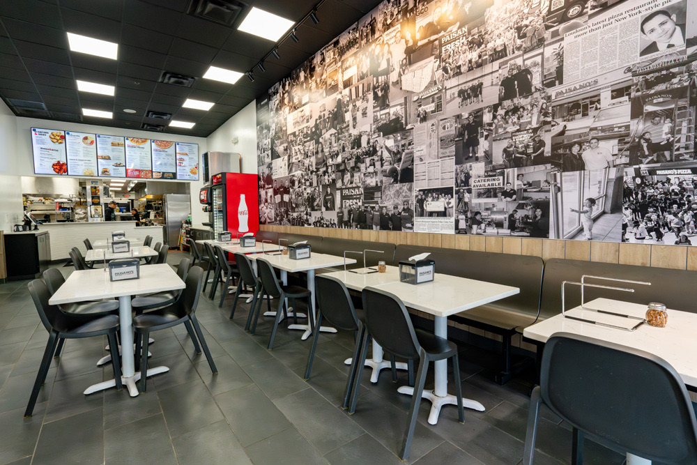 The dining room of a Paisano’s restaurant with its photo wall