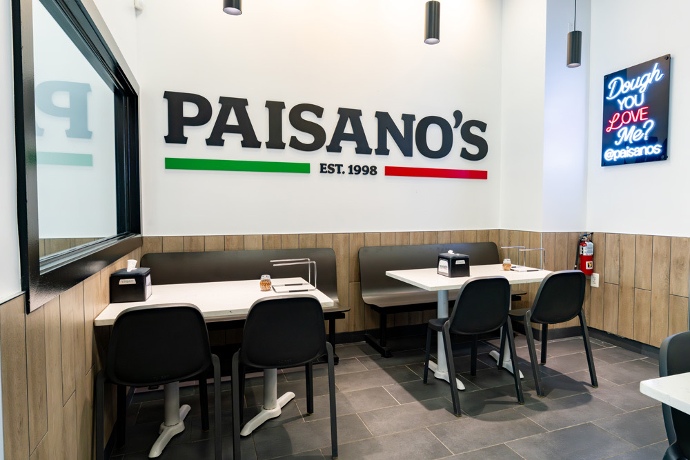 The Paisano’s logo wall and booths inside a Paisano’s restaurant