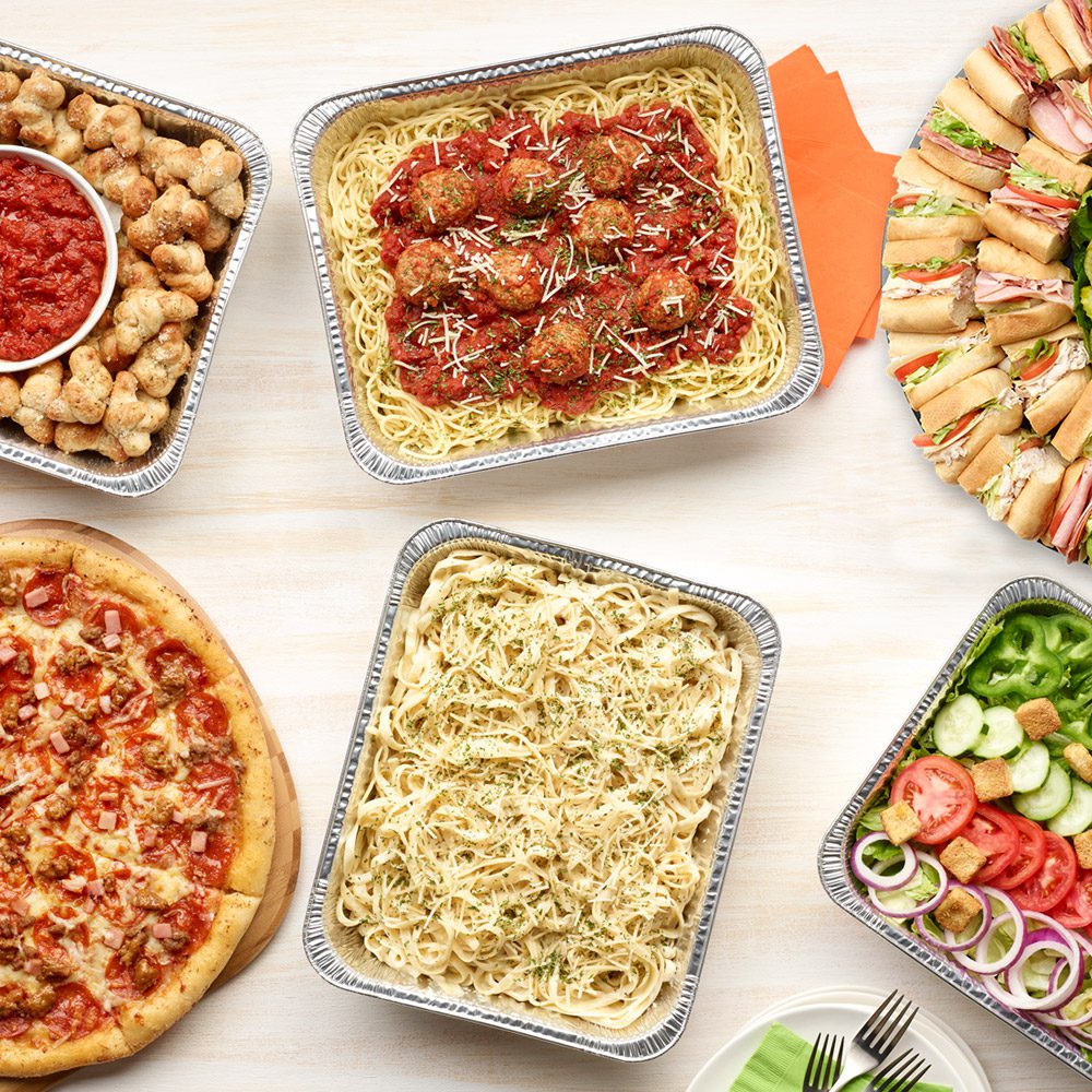 Paisano's catering spread of pizza, pasta, and salad